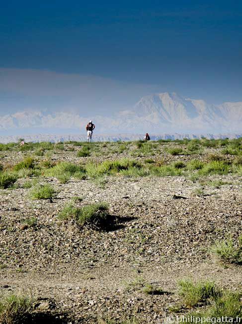 Runner during stage 1 with high mountains in the background (© P. Gatta)